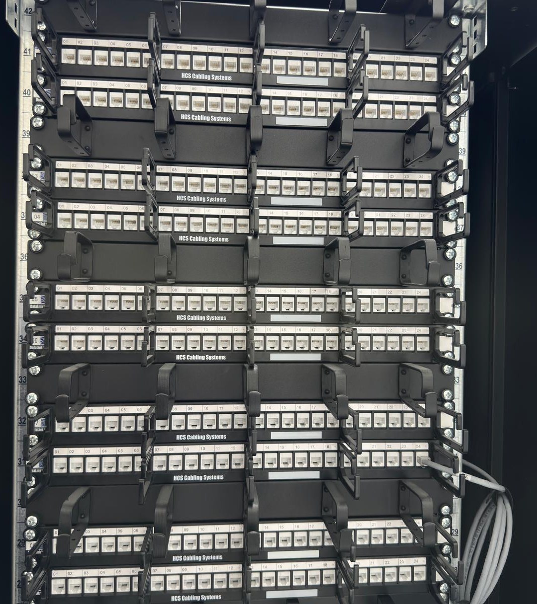 Acht gelabelde 24-poorts patchpanelen in een 19-inch kast